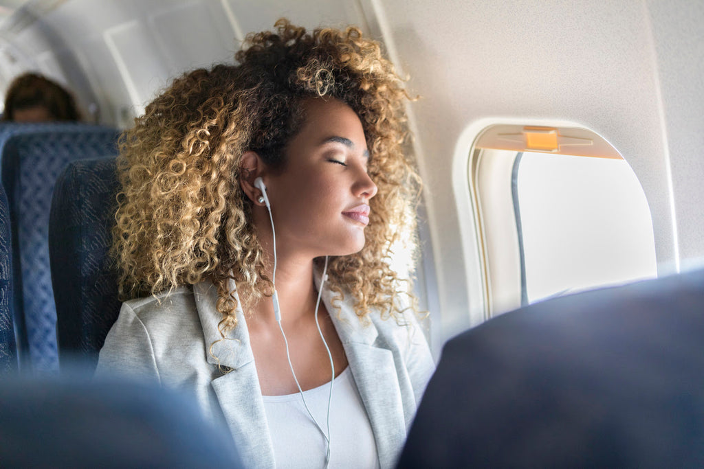 Woman sleeping on an airplane while traveling overseas